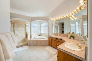 Primary Bathroom with tile patterned flooring, vanity, and shower with separate bathtub