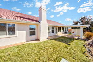 Back of property with a lawn and a patio area