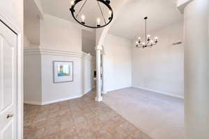 Foyer  and living room with  vaulted ceilings, and a chandelier