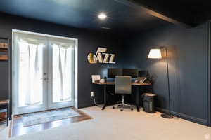 Home office with light colored carpet and french doors