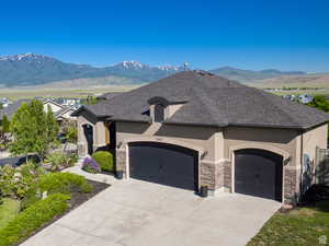 French country inspired facade featuring a garage and a mountain view