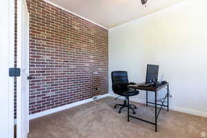 Carpeted office with brick wall