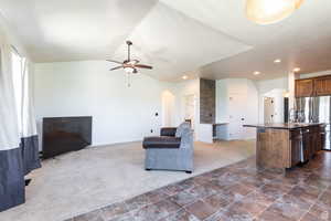 Carpeted living room featuring lofted ceiling and ceiling fan