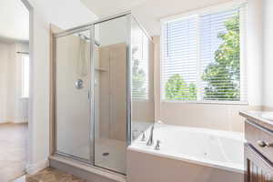 Bathroom featuring vanity and plus walk in shower