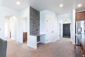 Kitchen with carpet floors, stainless steel fridge, and stone counters