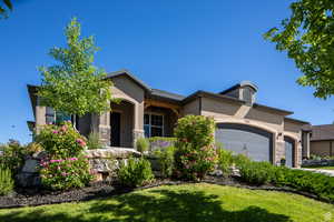 View of front of house featuring a garage and a front yard