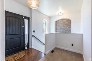 Entryway featuring dark colored carpet