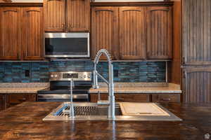 Kitchen featuring stainless steel appliances, tasteful backsplash, and sink