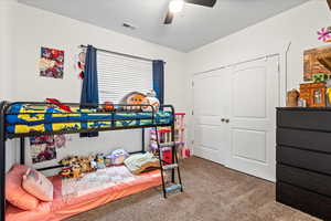 Bedroom featuring ceiling fan, carpet flooring, and a closet