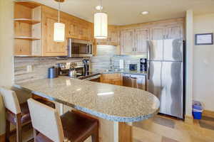 Kitchen with stainless steel appliances, sink, and light brown cabinets