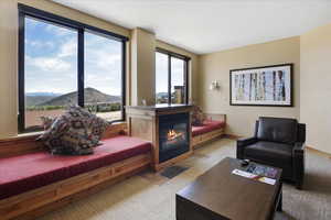 Living area with a healthy amount of sunlight, a mountain view, and light carpet