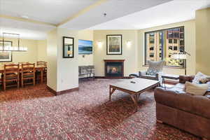 Carpeted living room with an inviting chandelier