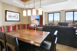 Dining room featuring a raised ceiling and a mountain view