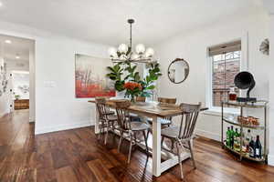 Dining space featuring dark hardwood / wood-style floors and an inviting chandelier