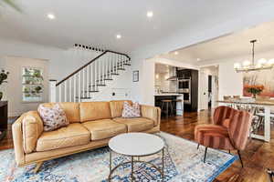 Living room with a notable chandelier and dark wood-type flooring