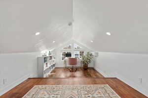 Interior space with lofted ceiling and hardwood / wood-style floors