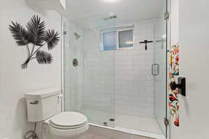 Bathroom with a shower with shower door and toilet