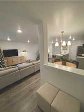 Living room with dark hardwood / wood-style floors and an inviting chandelier