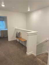 Hallway with dark colored carpet