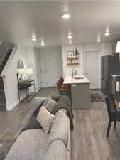 Living room with dark hardwood / wood-style flooring, sink, and a textured ceiling