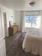 Carpeted bedroom featuring a textured ceiling