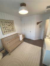 Carpeted bedroom with wooden walls