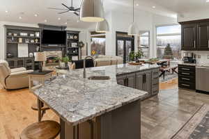 Kitchen with sink, hanging light fixtures, and a large island with sink