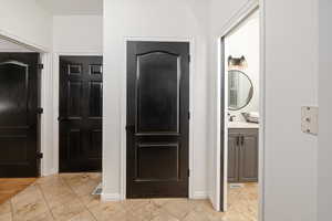 Hallway featuring sink and light tile patterned floors