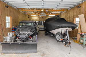 Garage featuring a carport and wooden walls