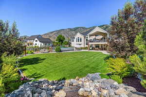 View of front facade featuring a mountain view, a front yard, and a patio area