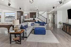 Living room with a wealth of natural light, wood-type flooring, and a textured ceiling