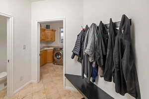 Mudroom with washer / clothes dryer, sink, and light tile patterned floors