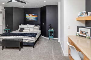 Bedroom with ceiling fan, carpet, and a textured ceiling