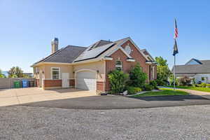 View of front of house featuring a garage and solar panels