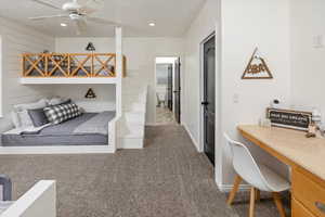 Bedroom featuring ceiling fan and dark carpet