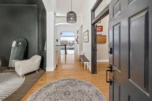 Foyer with wood-type flooring and ornamental molding