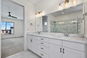 Bathroom with walk in shower, ceiling fan, and vanity