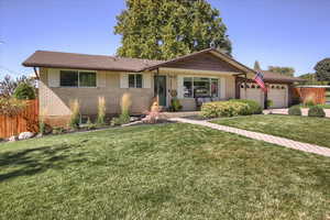 Ranch-style house featuring a garage and a front yard