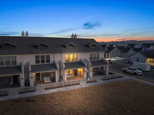 Back house at dusk featuring a patio