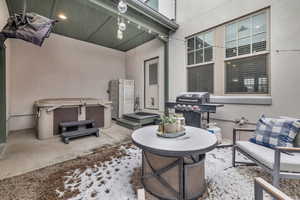 View of patio featuring a hot tub and a grill