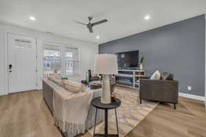 Living room featuring ceiling fan and light hardwood / wood-style flooring