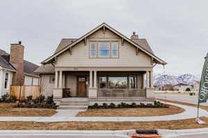 Craftsman house featuring covered porch, roof with shingles, a chimney, and a mountain view