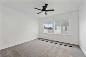 Spare room featuring ceiling fan and carpet flooring