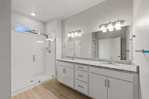 Bathroom featuring vanity and a shower with shower door