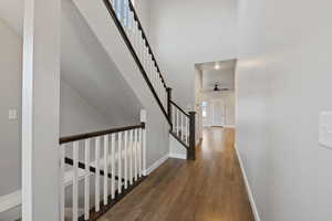 Corridor with dark hardwood / wood-style floors and a high ceiling