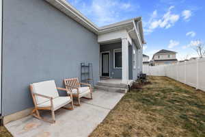 Entrance to property with a lawn and a patio