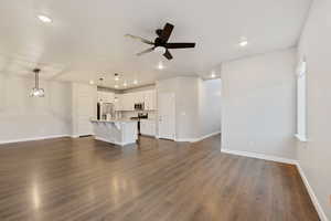 Unfurnished living room with dark hardwood / wood-style flooring, sink, and ceiling fan