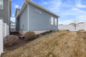 View of side of home with a lawn