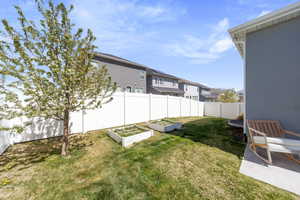View of yard with a garden, a fenced backyard, and a residential view
