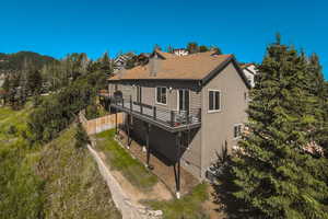 Rear view of house featuring a balcony and central air condition unit